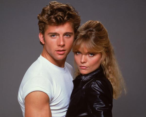 Bild 1 von 4: Es dauert nicht lange, bis sich Michael Carrington (Maxwell Caulfield, r.) in Stephanie (Michelle Pfeiffer, l.), die Anführerin der 'Pink Ladies', hoffnungslos verknallt. Die aber steht nur auf knallharte Motorrad-Biker ...