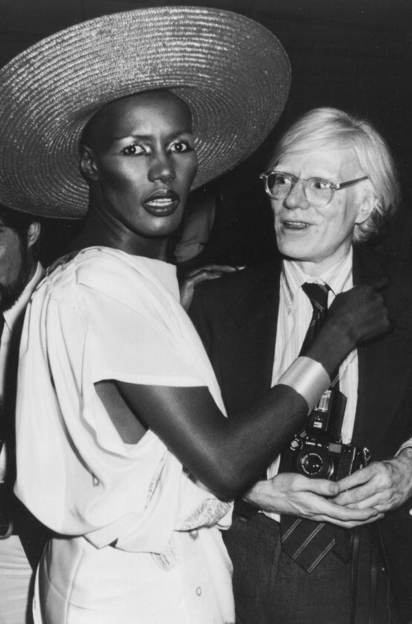 Bild 1 von 5: Die Sängerin und Schauspielerin Grace Jones neben Andy Warhol im legendären Studio 54