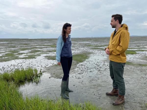 Bild 1 von 7: Im Bild: Benedict Feichtner mit  Meeresökologin Karin Didderen. Sie will mit moderner Technik die Küstengebiete der Niederlande renaturieren. Die Salzwiesen, die hier neu entstehen, schützen die Dämme vor Erosion und speichern CO2.