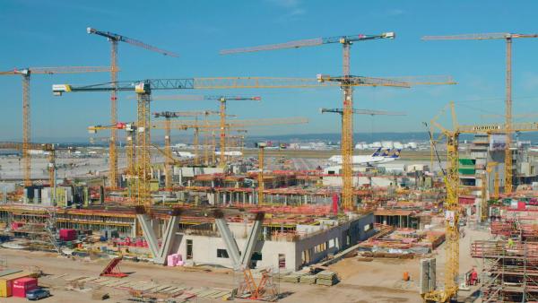 Bild 1 von 2: Auf der Baustelle herrscht ein buntes Treiben von Menschen und Maschinen inmitten von Bewährungsstahl. Doch was nach außen wie Chaos wirken möge, ist von den Bauleitenden des Projekts genaustens geplant.