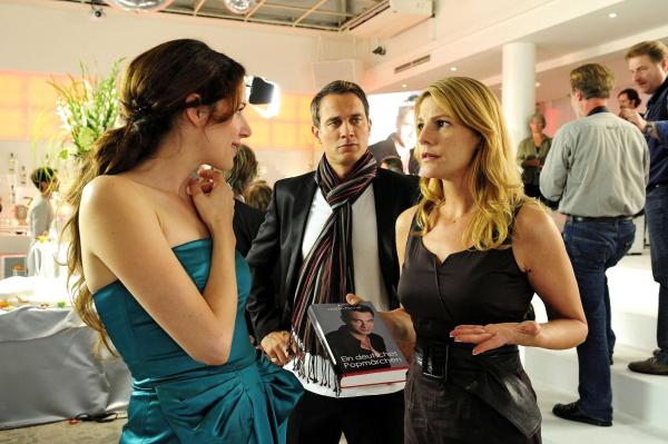 Bild 1 von 11: Claudia (Sophie Schütt, r.) stellt empört Verlagsleiterin Orphelia (Julia Malik, l.) zur Rede, dass sie nicht als Autorin von Martins (Ralf Bauer, M.) Biografie erwähnt wird.