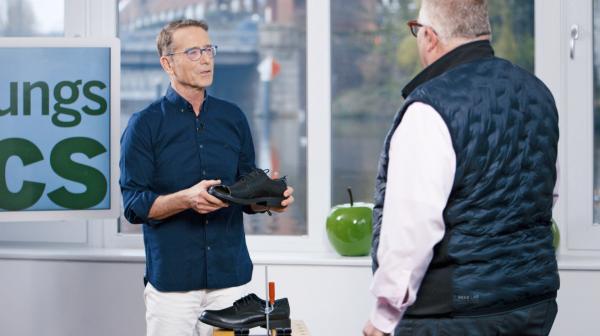 Bild 1 von 4: Mit der Stichsäge an den Lederschuh: Matthias Riedl zeigt Axel H., wie sehr die Gicht den Alltag schon im Griff hat. In seiner Not hatte der Unternehmer seinem Gicht-Zeh Luft verschafft.
