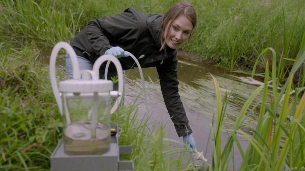 Bild 1 von 2: Charlotte Frie von der Universität Duisburg-Essen nimmt eine Umwelt-DNA-Probe in der Bade in Niedersachsen.