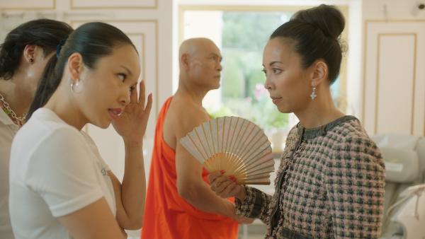 Bild 1 von 4: Tracy (Minh-Khai Phan-Thi, r.) möchte mit Hilfe eines Mönchs (Nguyet Pham Khac, M.) herausfinden, warum ihr Laden nicht gut genug läuft. Ly (Trang Le Hong, l.) meint die Antwort schon zu kennen.