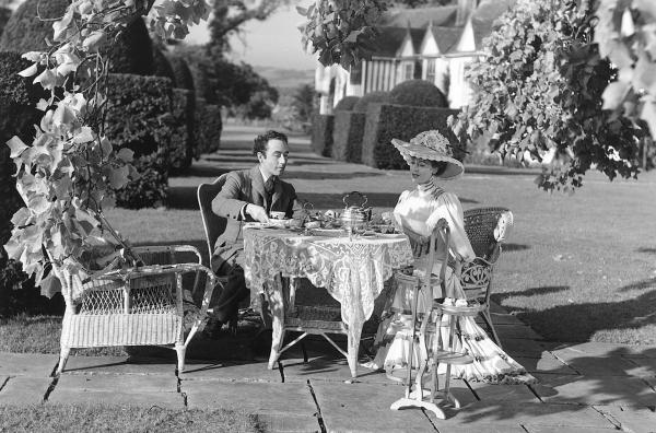 Bild 1 von 3: Seelenruhig sitzen Louis Mazzini (Dennis Price) und Edith D?Ascoyne (Valerie Hobson) für eine Teezeit beisammen. Edith ahnt nicht, welches Schicksal ihren Ehemann Henry bald ereilen wird.
