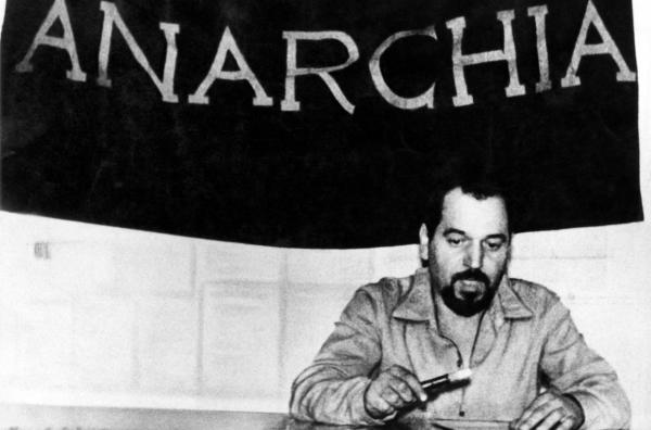 Bild 1 von 2: Der italienische anarchistische Aktivist Giuseppe Pinelli in den 60er Jahren: hinter ihm eine Flagge, auf der ?Anarchie? steht
