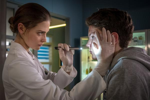 Bild 1 von 7: Dr. Grünberg (Laura Berlin, l.) nutzt die ärztliche Untersuchung, um Emil (Julius Störmer, r.) nach seiner häuslichen Situation zu fragen. Doch der Junge redet nicht mit ihr.