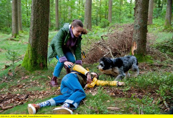 Bild 1 von 5: Nina (Annika Vieider) fällt mit Unterzucker um. Leo (Phillis Lara Lau) und Hund Jojo eilen herbei um zu helfen.