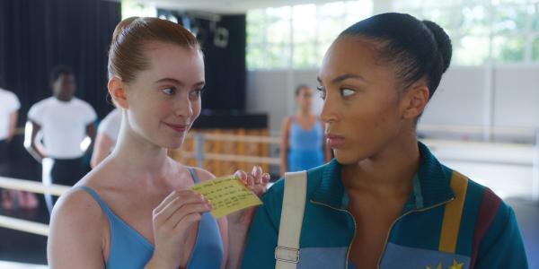 Bild 1 von 3: Mia (Abigail O'Regan, l. ) überreicht der genervten Cece (Hailey Romain, r.) den neuen, extra von ihr laminierten Trainingsplan.© ZDF/2023 Cottonwood Media/ZDF Studios/ Opéra National de Paris - Honorarfreie Verwendung gemäß AGB im engen inhaltlichen redaktionellen Zusammenhang mit genannter Sendung bei Nennung \