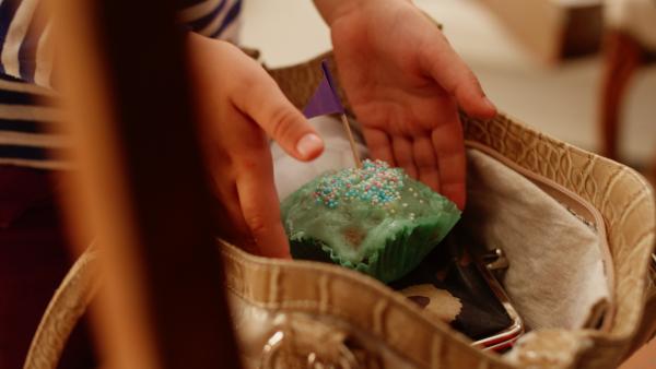 Bild 1 von 4: Vilda (Sofia Sittnikow) verteilt den Rest der Törtchen in den Taschen der Cafébesucher.