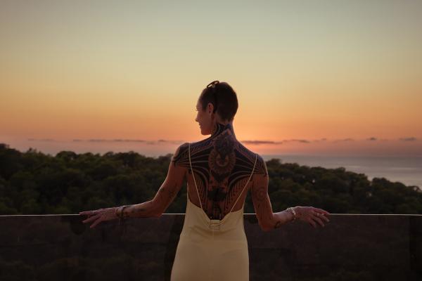 Bild 1 von 9: Auswanderin Helena Kammerer auf einem Balkon im Sonnenuntergang.