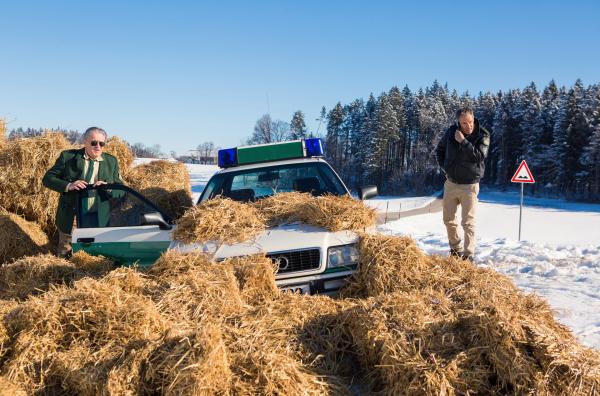 Bild 1 von 6: Die Bremsen am Streifenwagen haben versagt. Hubert (Christian Tramitz, rechts) und Girwidz (Michael Brandner, links) landen in einem Haufen aus Strohballen und kommen mit dem Schrecken davon.
