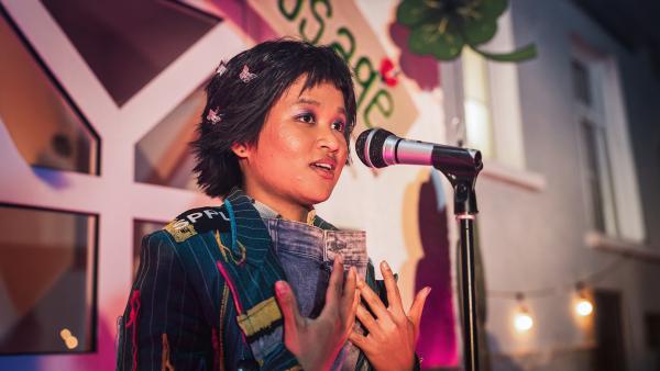 Bild 1 von 2: Massuda (Tisa Pharaschad Khumyim) steht am Mikro und findet die richtigen Worte.