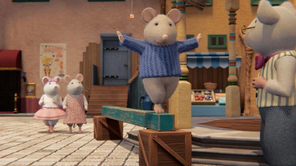 Bild 1 von 4: Beim mehrteiligen Wettkampf um den Großen Löffel, den sich Herr Quark (rechts) ausgedacht hat, balanciert Sam (2. von rechts) auf einem Balken. Dies ist der zweite Teil des Wettkampfs, den er gegen Ella (links) und Julia (2. von links.) gewinnen will, um als Erster das Fondue probieren zu dürfen.