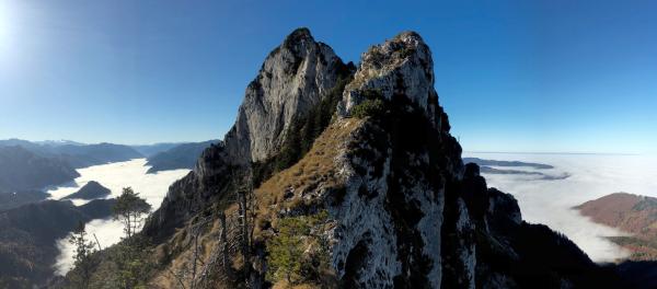 Bild 1 von 4: Die Silhouette des Traunsteins am Ostufer des Traunsees ist bereits aus über hundert Kilometern Entfernung sichtbar. Deshalb wird der Berg auch als Wächter des Salzkammergutes bezeichnet. Viele Künstler, Schriftsteller wie Nikolaus Lenau, bestiegen ihn, ebenso jagdfreudige Habsburger. Trotz seiner bescheidenen Höhe von 1.691 m ist er aber auch ein Berg voller Gefahren. Nur Europas höchster Berg, der Mont Blanc, forderte mehr Todesopfer als das gewaltige Kalksteinmassiv im oberösterreichischen Salzkammergut. Seine schroffen Bergwände fallen direkt in den See und das macht ihn für Bergsteiger zum herausfordernden Ziel und zum Fotomotiv für Menschen aus aller Welt. Im Bild: Blick vom Ostgrat auf die Gipfelpyramiden des Traunsteins.