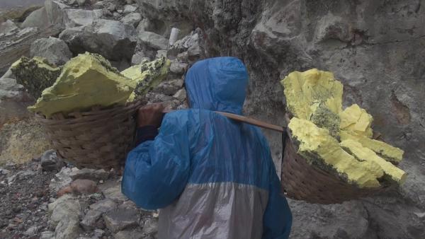 Bild 1 von 3: Die Schwefelstecher am Ijen tragen ihre bis zu 80 Kilo schwere Ausbeute auf den Schultern zum Rand des Vulkankraters hinauf.