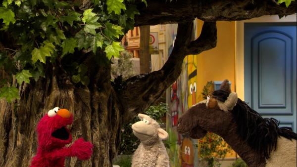 Bild 1 von 2: Elmo (links), Wolle (Mitte) und Pferd (rechts) überlegen, wie Elmo ins Baumhaus kommt.