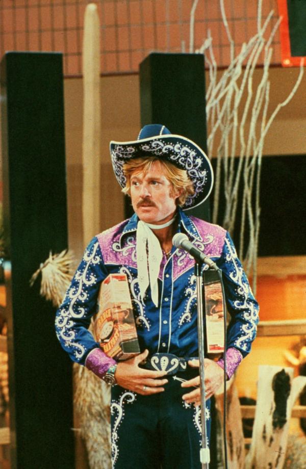 Bild 1 von 16: Rodeo-Champion Sonny (Robert Redford) reitet mit Glühlampen am Cowboy-Kostüm als Werbeträger für Cornflakes. Als ein Rassepferd für eine Show unter Drogen gesetzt wird, reitet er während der Gala in voller Montur mit dem Hengst davon.