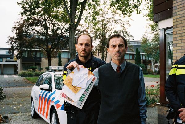 Bild 1 von 4: Der Nachbar (René van 't Hof) zeigt die Post, über die Kees gepinkelt hat. Der Polizist (Huub Smit) steht hinter ihm.