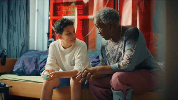 Bild 1 von 4: Tom (Noah Bailey, links) vertraut seinen Liebeskummer seiner Oma Senait (Robin Gooch, rechts) an, und die Oma bittet Tom, ihr bei der Wohnungssuche zu helfen.