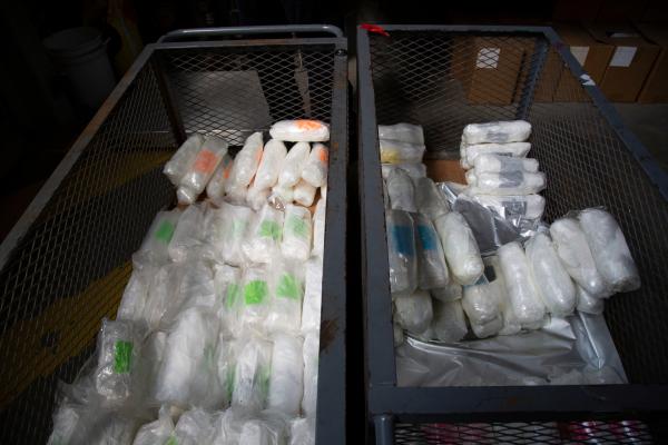 Bild 1 von 6: Various packages of suspected narcotics are sitting in two metal bins after being extracted from a suspect's vehicle.