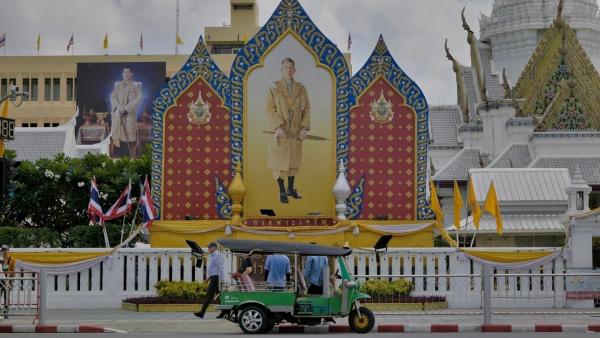 Bild 1 von 14: Am Fuße des City Pillar Shrine erinnert ein Porträt von König Rama X mit Schwert an die Machtansprüche des Monarchen.