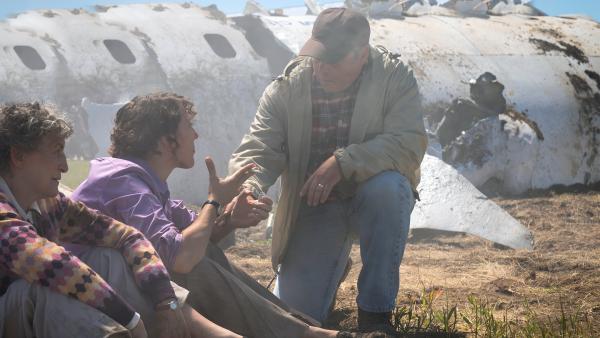 Bild 1 von 3: Ein Zivillist erkundigt sich bei zwei Passagieren nach ihrem Wohlbefinden.