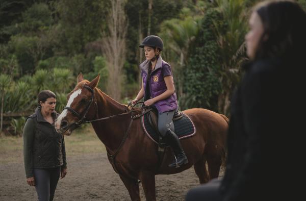 Bild 1 von 4: Issie (Macey Chipping, r.) muss mit ansehen, wie Ginty (Josephine Davison, l.) die Reitschülerin Nicole (Annise Boothroyd) auf Blaze ausreiten lässt. Gefühlt ist Blaze Issies Pferd, doch tatsächlich gehört es ihr nicht.