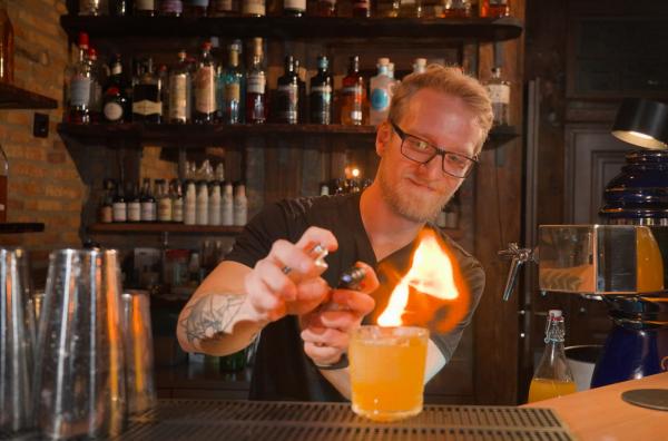 Bild 1 von 3: Joschka Pelgen von der Mainzer Spiritus Bar flambiert einen Exotic Juice als Hausvariante des Gimlet Cocktails.