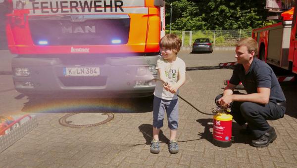 Bild 1 von 7: Moritz bei der Feuerwehr. Dort darf er gemeinsam mit echten Feuerwehrleuten den Wasserschlauch halten.