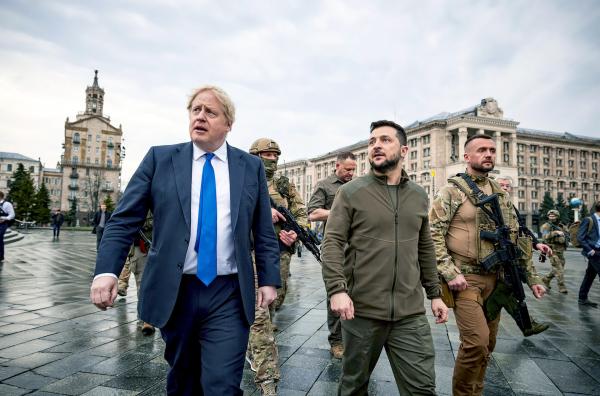 Bild 1 von 2: Der ukrainische Präsident Wolodymyr Selenskyj (Mi.), der damalige britische Premierminister Boris Johnson (li.) und Sicherheitskräfte am 9. April 2022 auf dem Maidan im Zentrum von Kiew