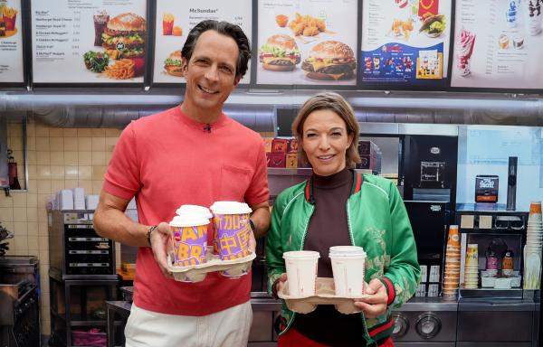 Bild 1 von 3: Jo Hiller und Anna Planken mit Getränken vor einer McDonalds-Filiale.
