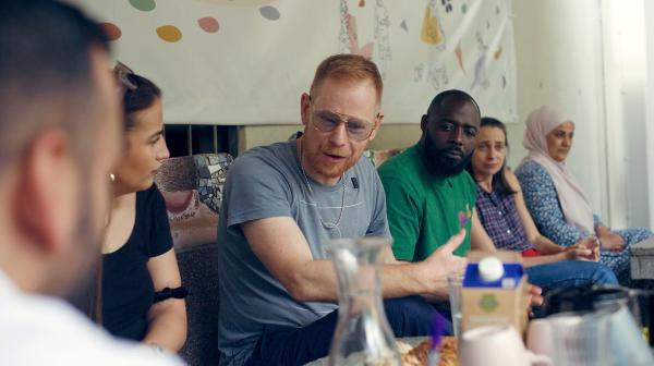 Bild 1 von 3: Peter Fox gemeinsam mit Prince und verschiedenen Sozialarbeiter*innen bei der Planung der \