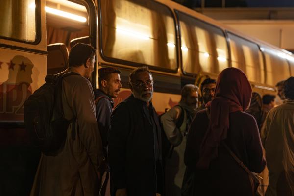 Bild 1 von 13: Mit gemieteten Bussen will Baqir (Vassilis Koukalani, 3.v.l.) die Afghanen und das Personal der französischen Botschaft zum Flughafen Kabul bringen. Doch er macht sich Sorgen um seine Frau Zahara. Als Staatsanwältin steht sie auf der Todesliste der Taliban. Wie soll sie unerkannt entkommen?