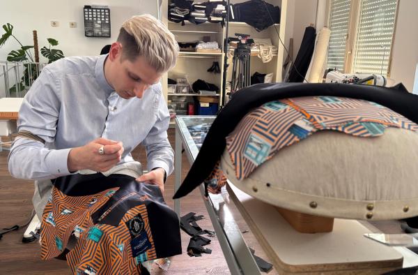 Bild 1 von 8: Herrenschneider Dominik Häusler aus Stuttgart arbeitet an Revers und Seide.