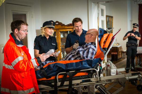 Bild 1 von 8: Helmut Freitag (Hans Teuscher, liegend) wurde niedergeschlagen. Während Dr. Haase (Fabian Harloff, 2.v.r.) ihn verarztet, versucht Melanie (Sanna Englund) herauszubekommen, an was sich der alte Herr erinnert.
