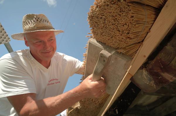 Bild 1 von 2: Reetdachdecker Walter Epting gestaltet die Traufe.