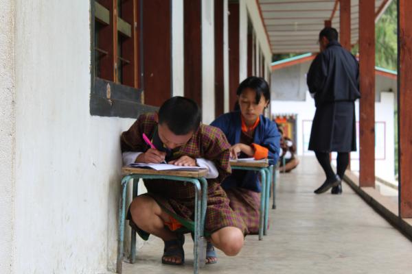 Bild 1 von 6: Tshering brütet über dem Mathetest, während ihr Lehrer kontrolliert.