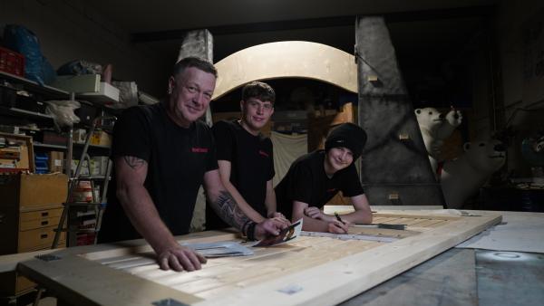 Bild 1 von 4: Kulissenbauer Angelo Zannin (l.) und seinen Söhne bauen das Eingangstor aus den \