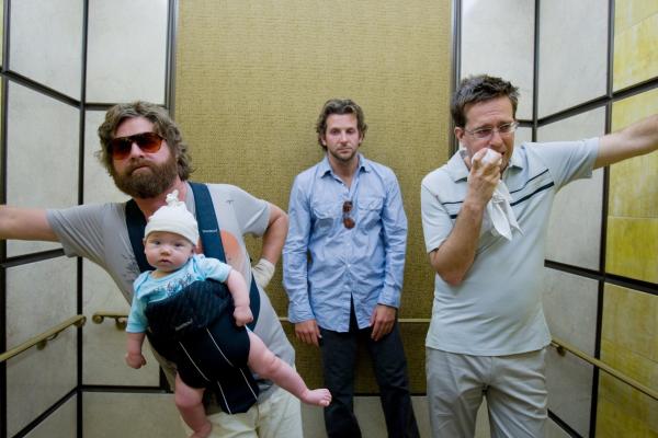 Bild 1 von 6: Zach Galifianakis as Alan holding baby Tyler in front pack carrier, standing in elevator with Bradley Cooper as Phil and Ed Helms as Stu.