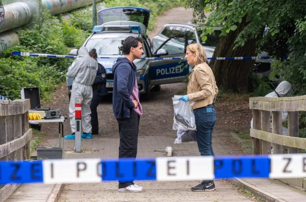 Bild 1 von 6: Tamara Meurer (Anja Pahl) und Samir Amari (Skandar Amini) kommen an dem Tatort an, wo der Beamte verletzt wurde. Von Gabriel, der den Notruf abgesetzt hat, fehlt jede Spur. (Komparsen im Bild)