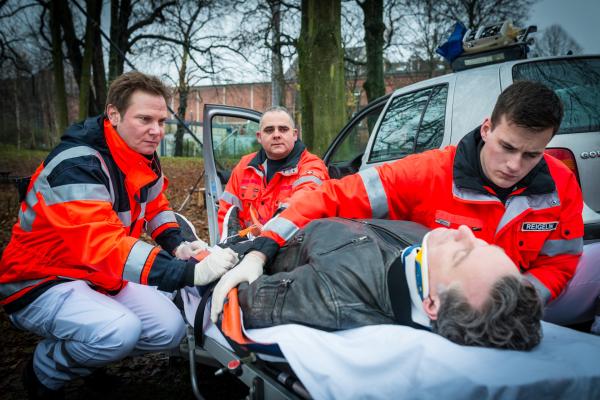 Bild 1 von 9: Dr. Haase (Fabian Harloff, l.) und seine Kollegen (Komparsen) kümmern sich um den verletzten Fahrer (Dirk Borchardt, M.) des Unfallwagens.