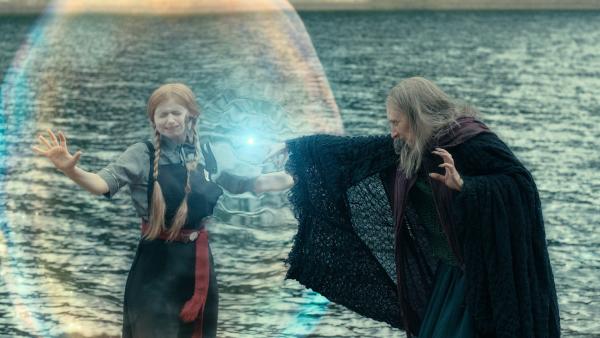 Bild 1 von 5: Am Kristallsee wollte Mildred (Lydia Page, l.) die junge Jessica Nieswurz treffen, die sie am Morgen zufällig im Zauberspiegel kennengelernt hatte. Doch nun hat sie es mit einer alten Hexe (Wendy Patterson) zu tun, die Mildreds Magie für sich haben will. Hoffentlich kann Mildred den Schutzzauber um sich herum lang genug aufrecht erhalten.
