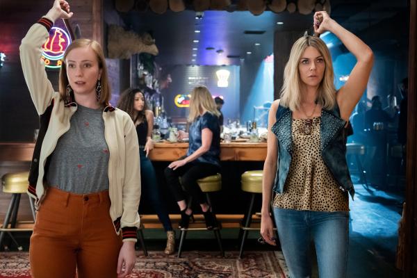 Bild 1 von 2: Nach einem erfolgreichen Tag auf der Messe, bei der DJ Vance (Kaitlin Olson, r.) zusammen mit Ava (Hannah Einbinder, l.) ihren selbstgemachten Schmuck promotet haben, lassen die beiden den Abend in einer Bar ausklingen. Doch dann enthüllen ihre Freunde ein schockierendes Geheimnis über DJ Vances Nebeneinkommen - ganz zum Entsetzen von Ava.