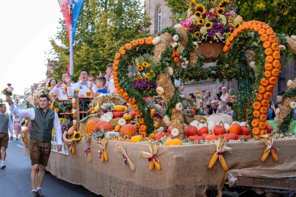Bild 1 von 2: Geschmückter Festwagen mit Erntekrone aus Kürbissen und Blumen.
