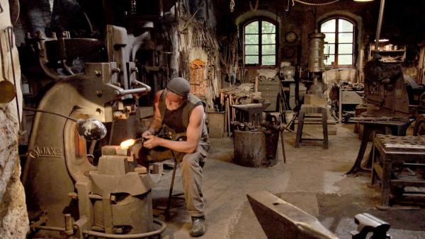 Bild 1 von 7: Im Bild: Der Schmiedemeister Sepp Eybl bei seiner harten Arbeit im Hammerwerk in Ybbsitz.