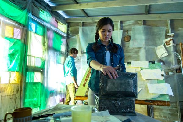 Bild 1 von 7: Kyra (Kimie Tsukakoshi rechts) und Darra (Julian Cullen links) durchsuchen ein Strandhaus. Hier hatte der verschwundene Architekt der Bibliothek sein Atelier.  Eine leere Schatulle fasziniert Kyra.