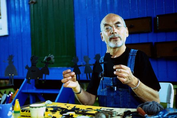 Bild 1 von 4: Peter (Peter Lustig) hat seine Leidenschaft für das Puppentheater entdeckt. Hier hat er sich für eine Schattentheatervorführung eine Menschenkette aus Papier ausgeschnitten.