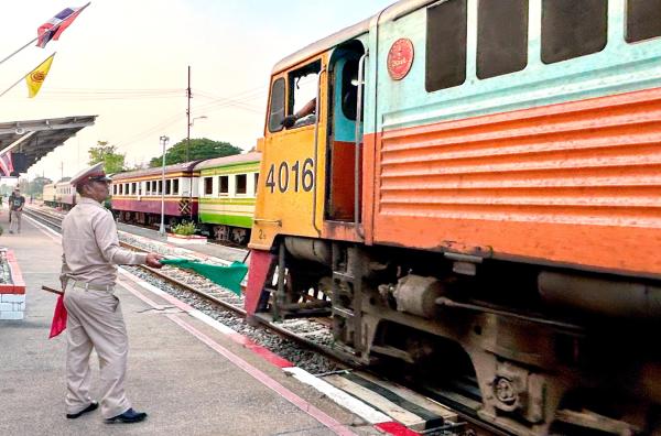 Bild 1 von 4: Mit grünen Fahnen geben die Fahrdienstleiter an den thailändischen Bahnhöfen die Einfahrt frei.