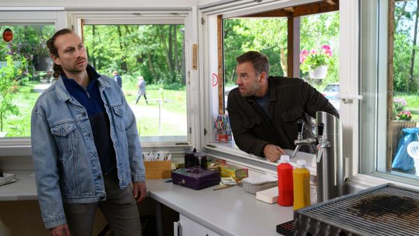Bild 1 von 5: Am Neuklostersee ist ein Mann getötet worden. Der Verdacht fällt sofort auf David Jung (Julius Robin Weigel, l.), dessen Imbissbude massive Einbußen durch die neue Foodtruck-Konkurrenz des Toten verkraften musste. Hauptkommissar Lars Pöhlmann (Dominic Boeer, r.) nimmt ihn deshalb genau unter die Lupe.